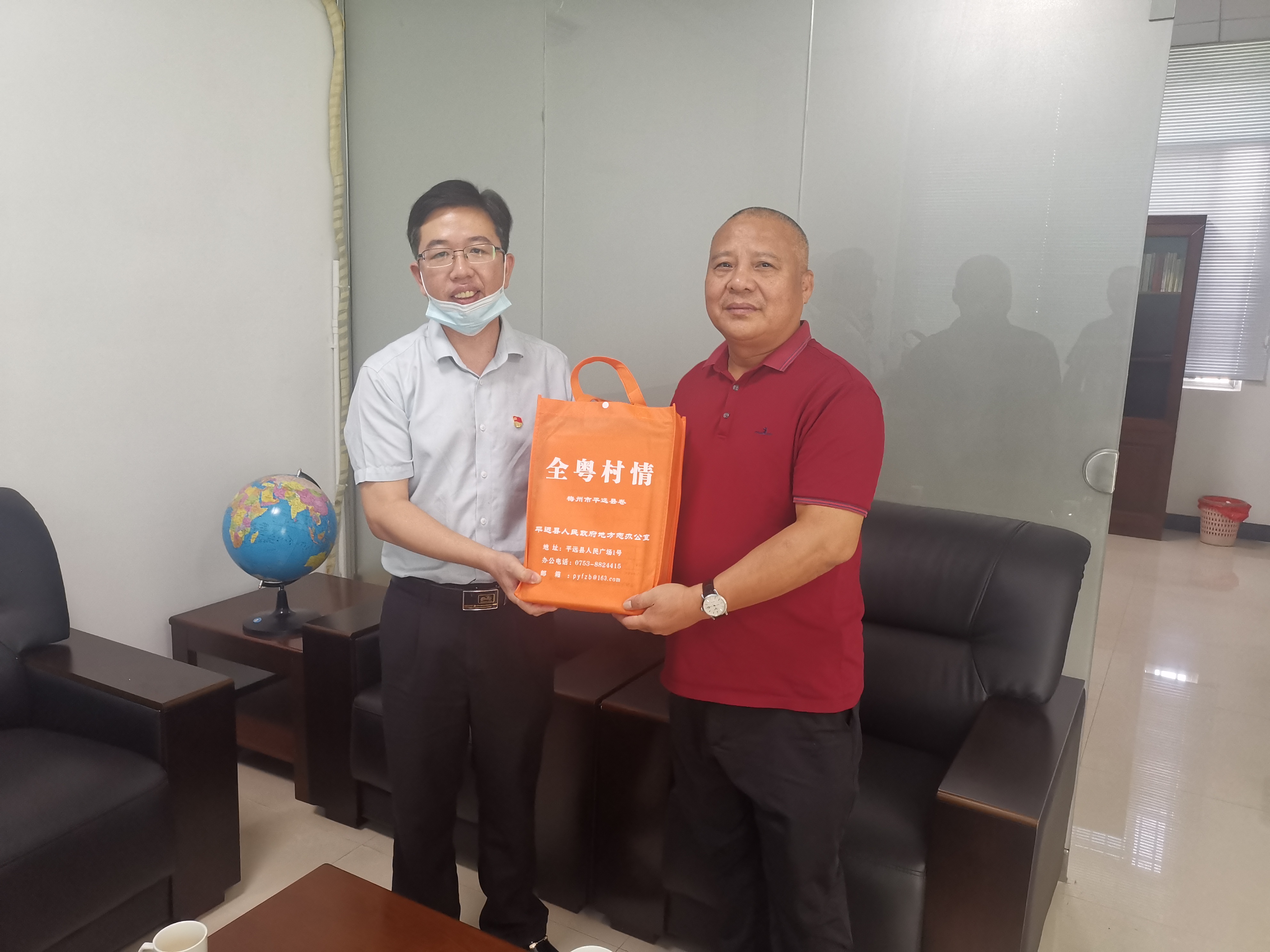 县地方志办支部书记、主任姚志粦（左）向城东社区党委书记钟建新（右）赠书（吴嘉业摄于2022年）.jpg